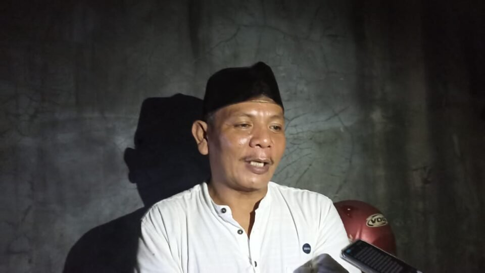 Teks: Ketua RT 36, Kelurahan Lok Bahu, Kecamatan Sungai Kunjang, Andri Herpanda.